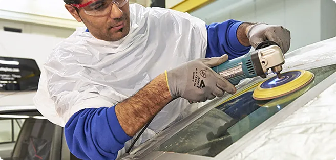 Man polishing a car window.
